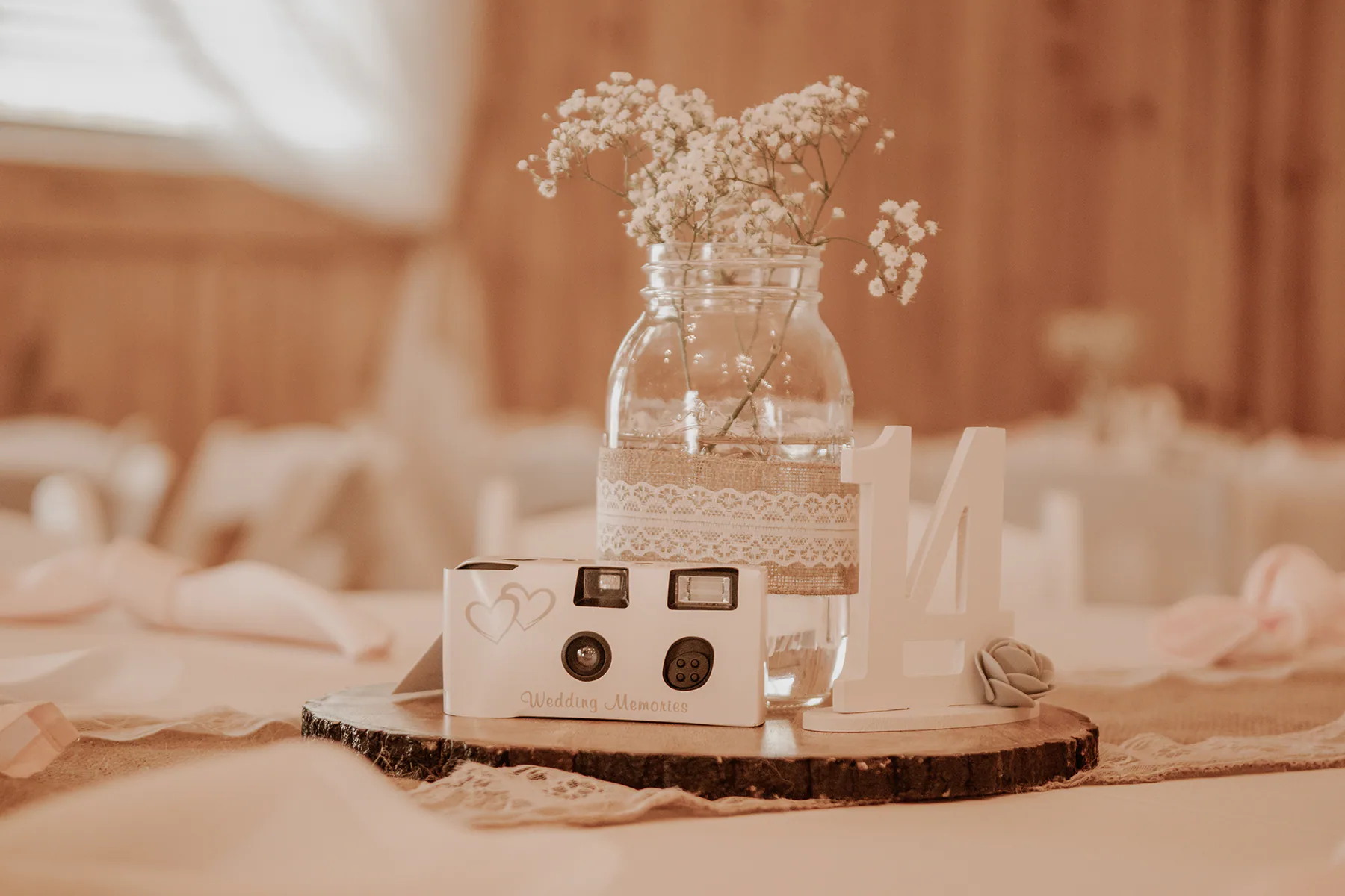 Instant camera and a jar of baby's breath on a reception table inside the Diamond L barn