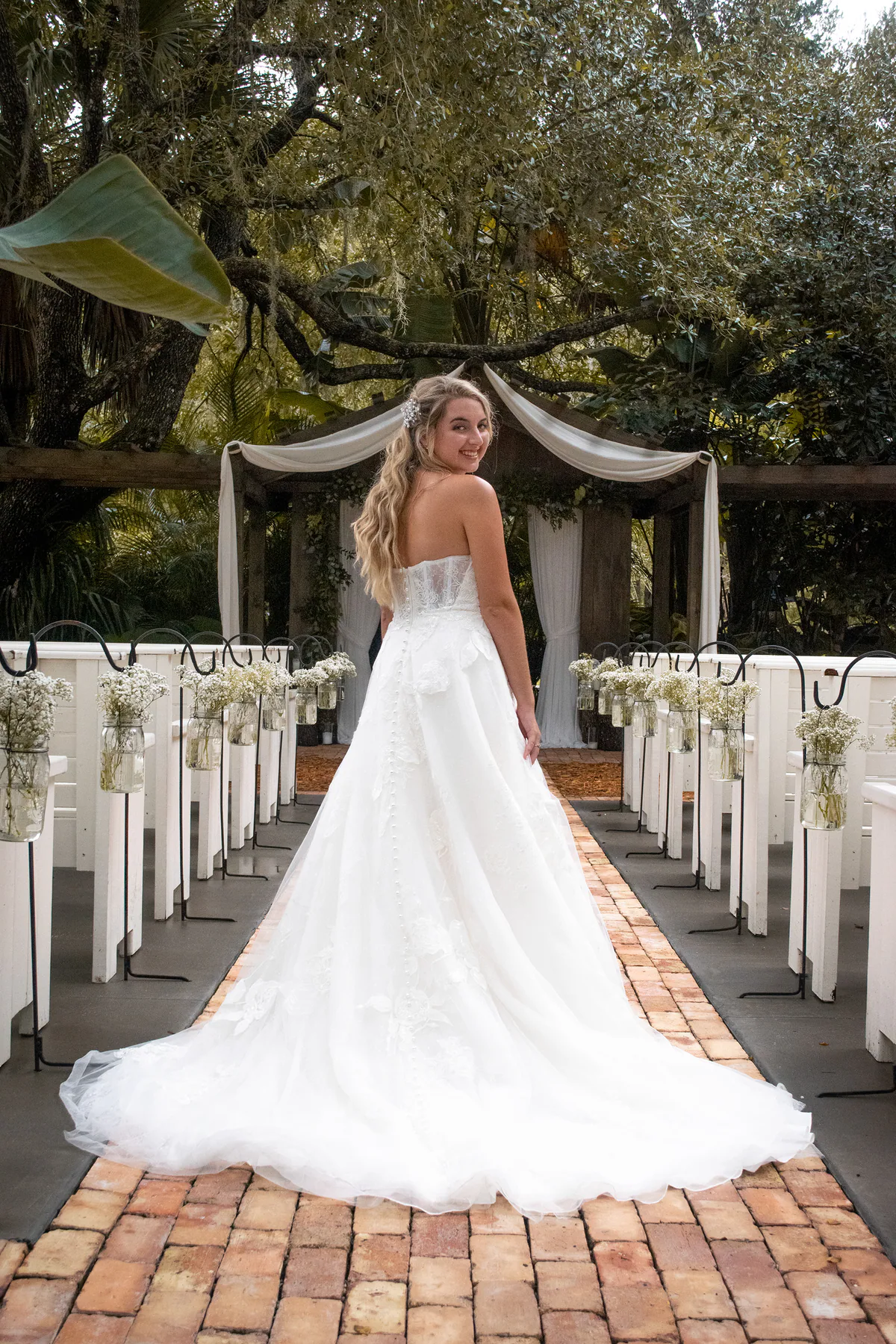 Bride looking back along the outdoor ceremony aisle at The Delamater House